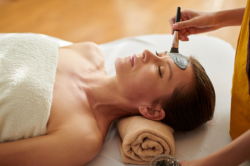 Cropped image of middle-aged woman getting rejuvenating procedure for face in beauty salon