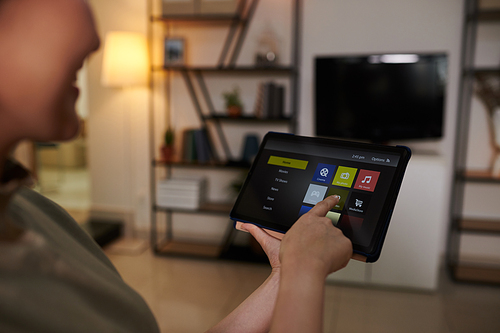 Hands of woman turning on smart tv application on tablet computer