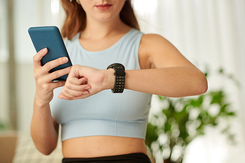 Young woman checking fitness tracker on her wrist