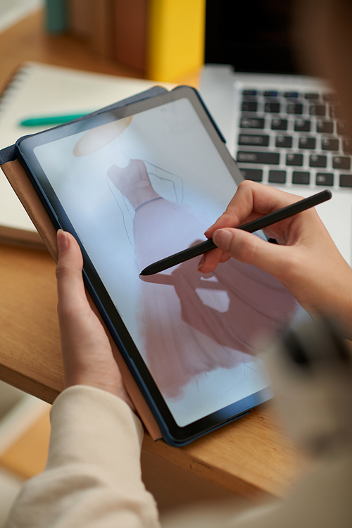 Closeup image of creative woman drawing fashion sketches on digital tablet