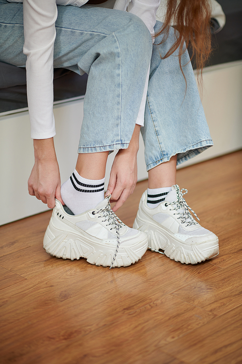 Cropped image ofwoman putting on sneakers