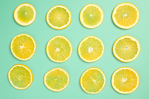 Thin orange slices on teal table, top view