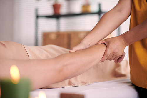 Cropped image of physiotherapist giving arm massage to male client