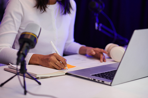 Female blogger writing down script before recording video for her blog