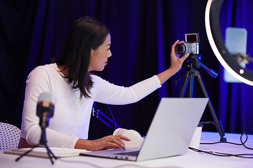 Blogger setting camera for filming blog in her studio