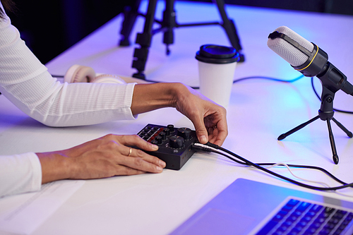 Hands of blogger setting amplifier before recording video for social media