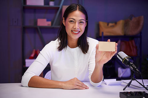 Portrait of smiling beauty blogger filming review of new product