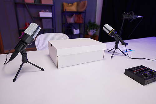 Two microphones and white box on table in studio of beauty blogger