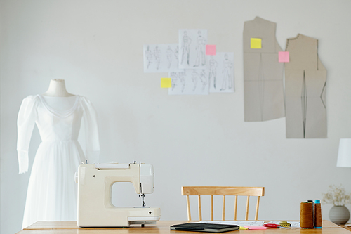 Desk of seamstress with sewing machine and planner in studio