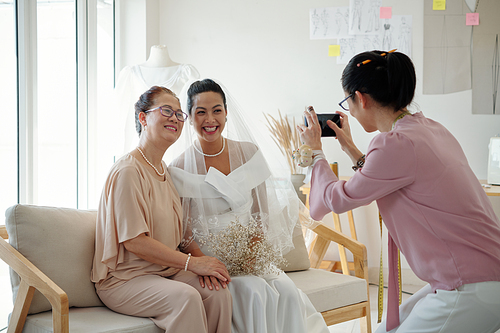 Bride and her mother posing for photo in fashion atelier