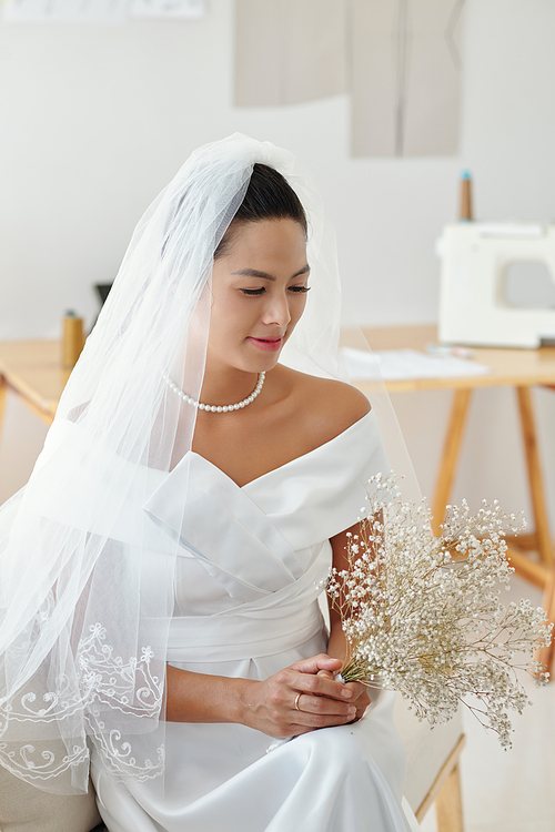 Beautiful bride with small bouquet waiting for groom