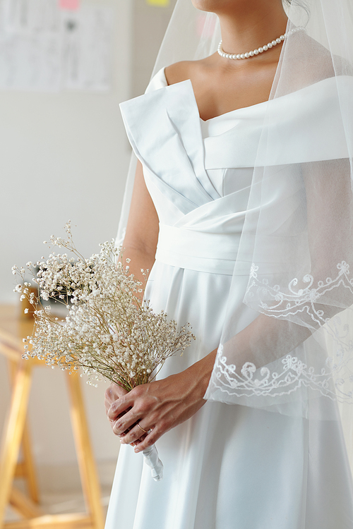 Cropped image of bride with minimalistic bouquet