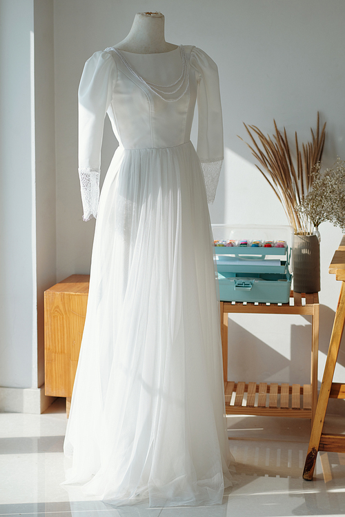 Beautiful elegant wedding dress on mannequin in sewing atelier