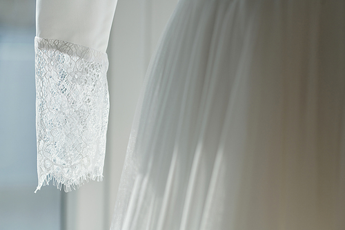 Lace sleeve of elegant gown in wedding salon