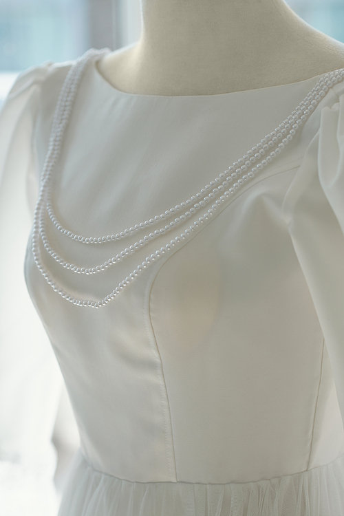 White pearl necklace on mannequin in wedding salon