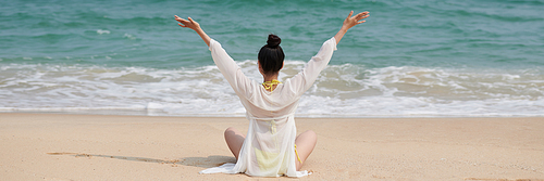 Header with young woman sitting on sea beach greeting rising sun