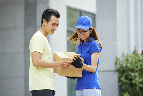 Courier and customer checking delivery details in mobile application