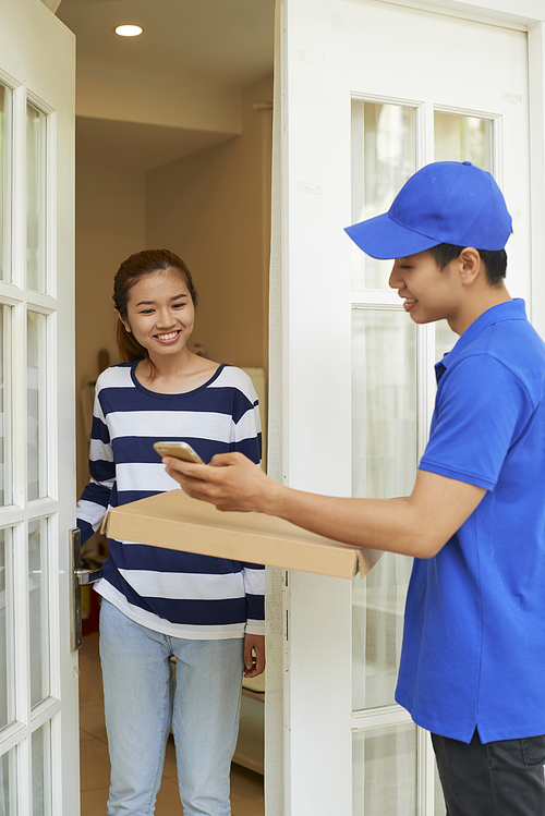 Mobile delivery servce representative in blue uniform bringing package to young woman