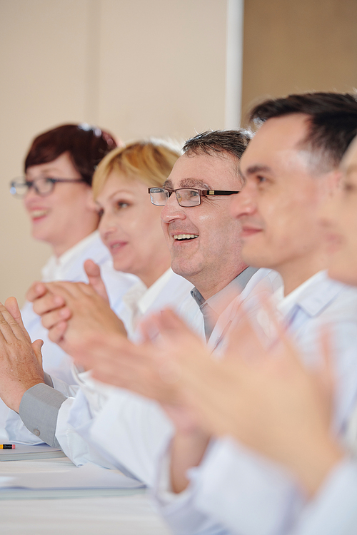 Excited mature scientist clapping when attending medical conference devoted to development of new coronavirus vacation