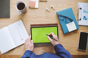 Hands of entrepreneur checking product presentation on tablet computer, view from above