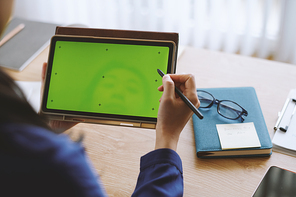 Business person watching presentation on tablet computer with green screen