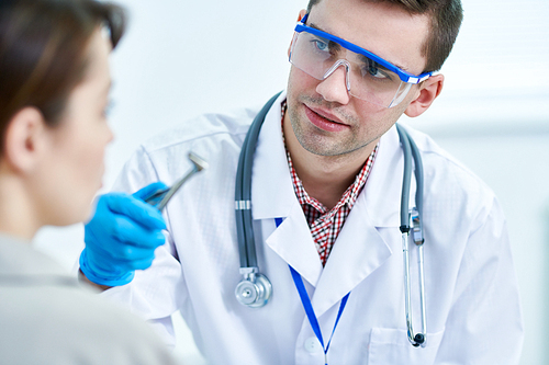 Portrait of young physician preparing to examine patient in clinic, copy space