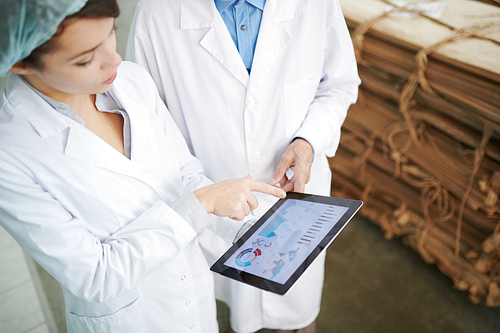 High angle portrait of  two factory workers using digital tablet while inspecting production at recycling plant, copy space