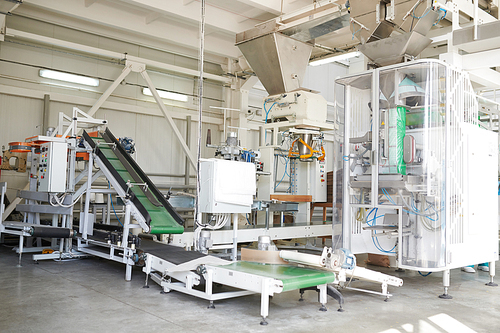 Interior of production workshop at food factory, group of modern packaging line units , copy space