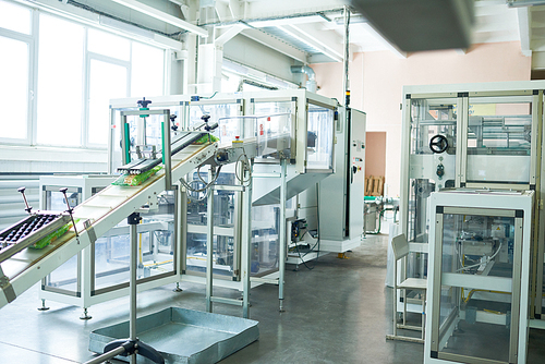 Interior of production workshop at food factory, modern assembly line units for packaging, copy space