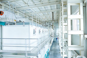High angle view at interior of clean production workshop at food factory, modern machine units lining long hall, copy space