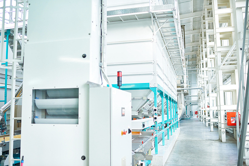 Interior of clean production workshop at modern factory, big machine units lining long hall, copy space