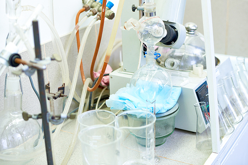 Close up of test tubes, beakers,  tools and equipment on table in science laboratory