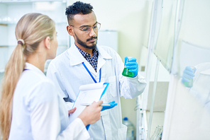 Team of young scientists working together studying chemicals and vaccines in medical  laboratory, copy space