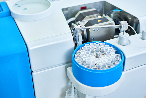 Close up of modern analyzing machine processing test tubes with probes in medical laboratory, copy space