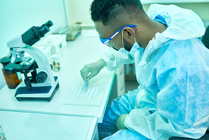 High angle portrait of young Middle-eastern scientist  working with substances in laboratory doing medical research