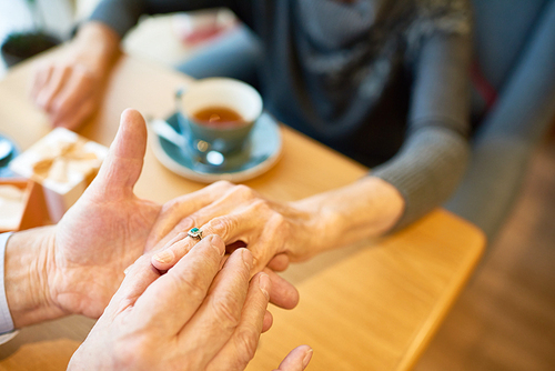 Close-up shot of unrecognizable senior man making marriage proposal to his soulmate at restaurant