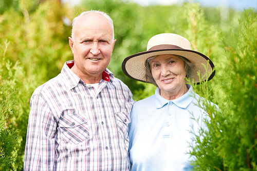 Portrait of loving elderly couple posing in garden  and smiling, copy space