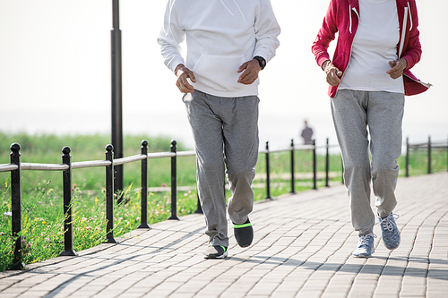 Low section portrait of unrecognizable active senior couple enjoying morning run outdoors in sunlight, copy space