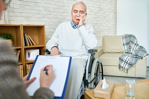 crop therapist having meeting with . senior man in cozy room of assisted living center.