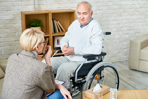 high angle portrait of . senior man in wheelchair sharing problems with psychiatrist during therapy session, copy space