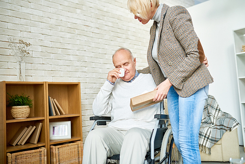 Portrait of female psychiatrist consoling crying senior man in wheelchair during therapy session, copy space