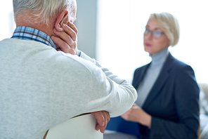 Back view  of sad senior man talking to female therapist during consultation, copy space