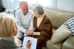 Portrait of nice senior couple visiting psychologist sharing problems in therapy session