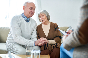 Portrait of nice senior couple holding hands visiting psychologist sharing problems in therapy session