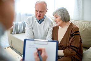 Portrait of nice senior couple visiting psychologist holding clipboard  sharing problems in therapy session