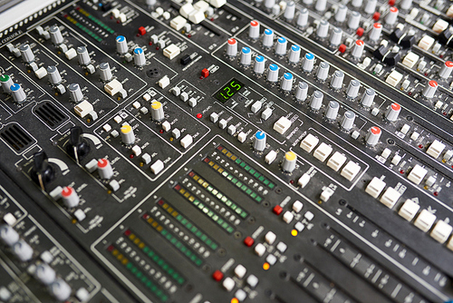 From above shot of controlling console with knobs and lights in studio of music recording.