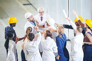 High angle view at group of angry factory workers attacking managers during strike