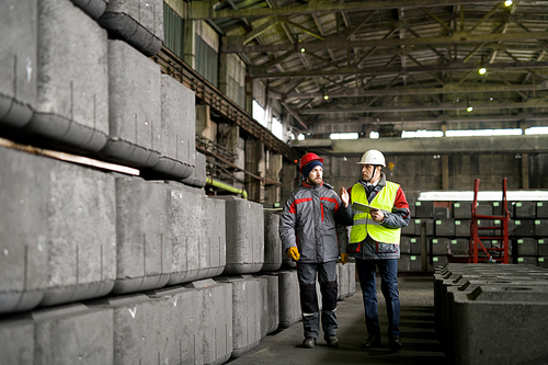 Full length portrait of two workers walking across workshop in modern industrial plant, copy space