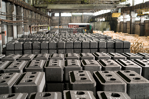 Background image of concrete blocks in warehouse of graphite plant, copy space