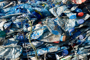 Close up background of crushed block of packed plastic bottles at modern recycling factory, copy space